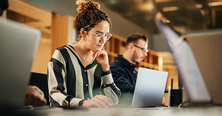 young woman in the workplace looking at laptop