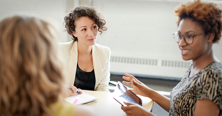 three women advocating at a meeting