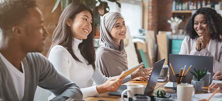 diverse colleagues seated at table at work