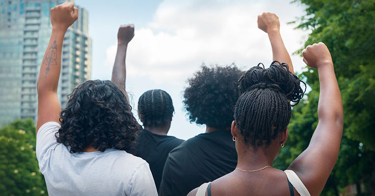 four individuals with arms raised