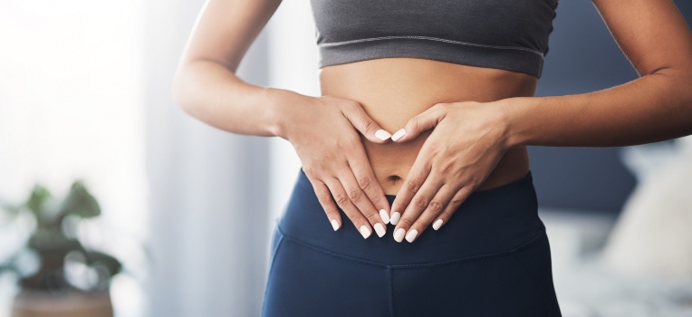 woman making a heart shape around her stomach