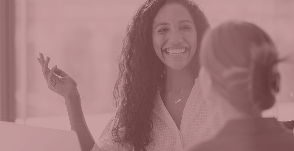 happy woman gesturing to colleague