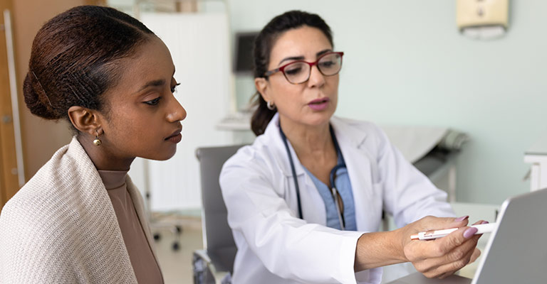 doctor reviewing results on laptop screen with patient