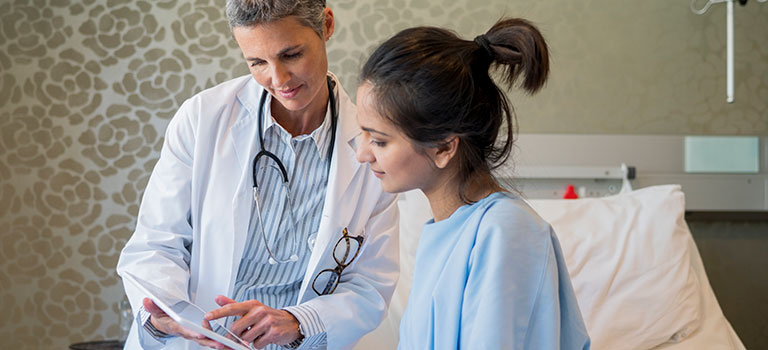 doctor speaking with seated female patient