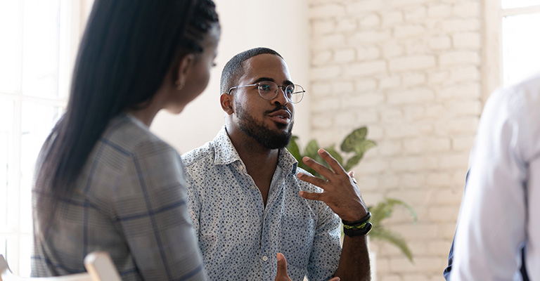 young man explaining with gestures at a work meeting