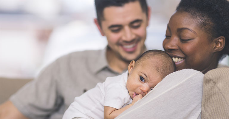 happy couple with mother holding infant