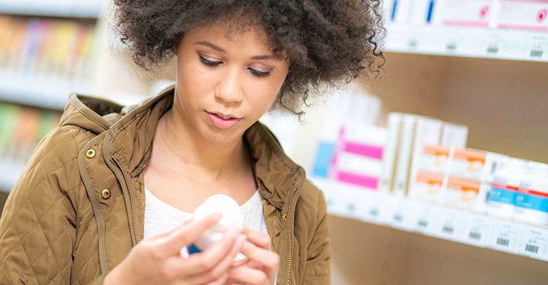woman looking at medicines at the pharmacy