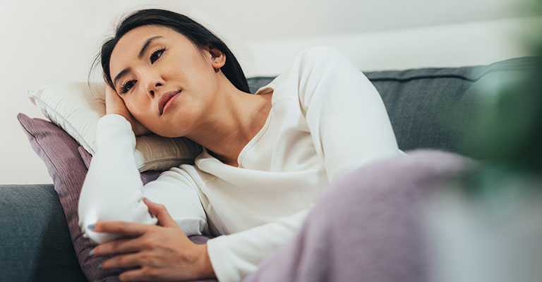 young woman resting on the couch after egg retrieval procedure