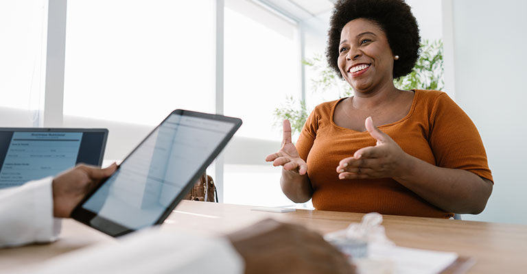 woman gesturing to provider who is looking at a phone