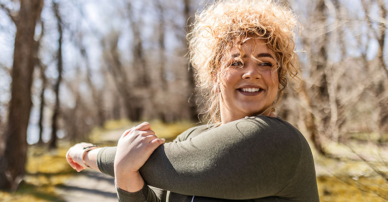 woman stretching her arms in the park