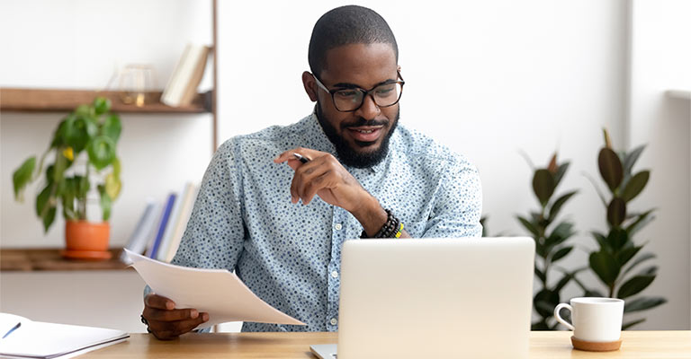 Man watching a webinar on his computer at work
