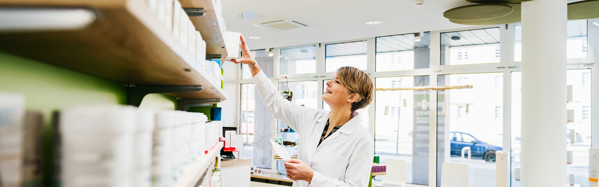 pharmacist reaching for shelf