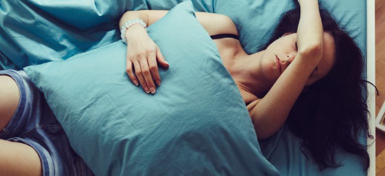 resting woman with her arm over her eyes