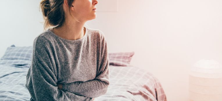 woman with arms wrapped around stomach