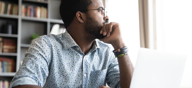 contemplative Black man looking out the window