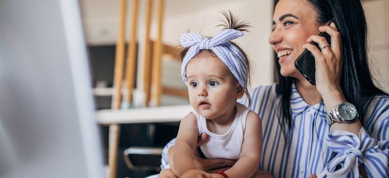 curious baby seated on happy mother's lap