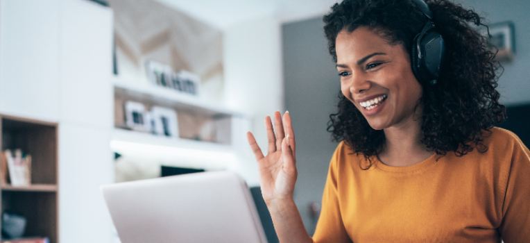 waving woman with headphones on a Zoom call
