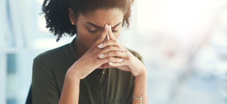 stressed woman with her hands supporting her head