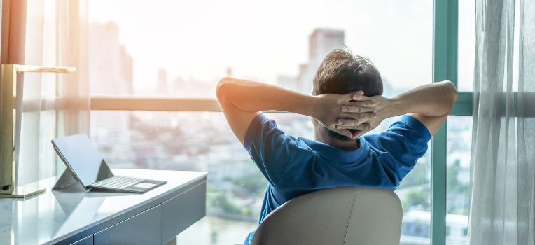 seated man lounging with his hands behind his head