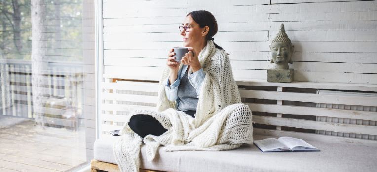 woman on porch with blanket wrapped around her