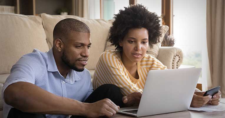a couple looking at a laptop screen