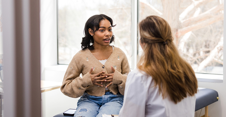 young woman speaking with medical provider at the doctor's office