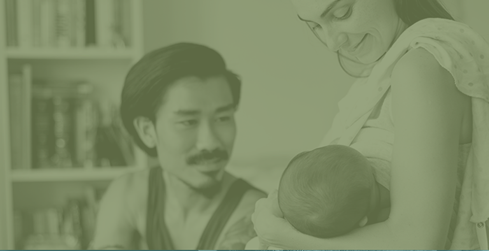 happy couple looking at their baby on a green background
