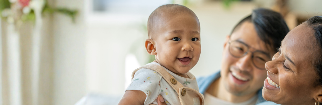 happy baby held up by parents